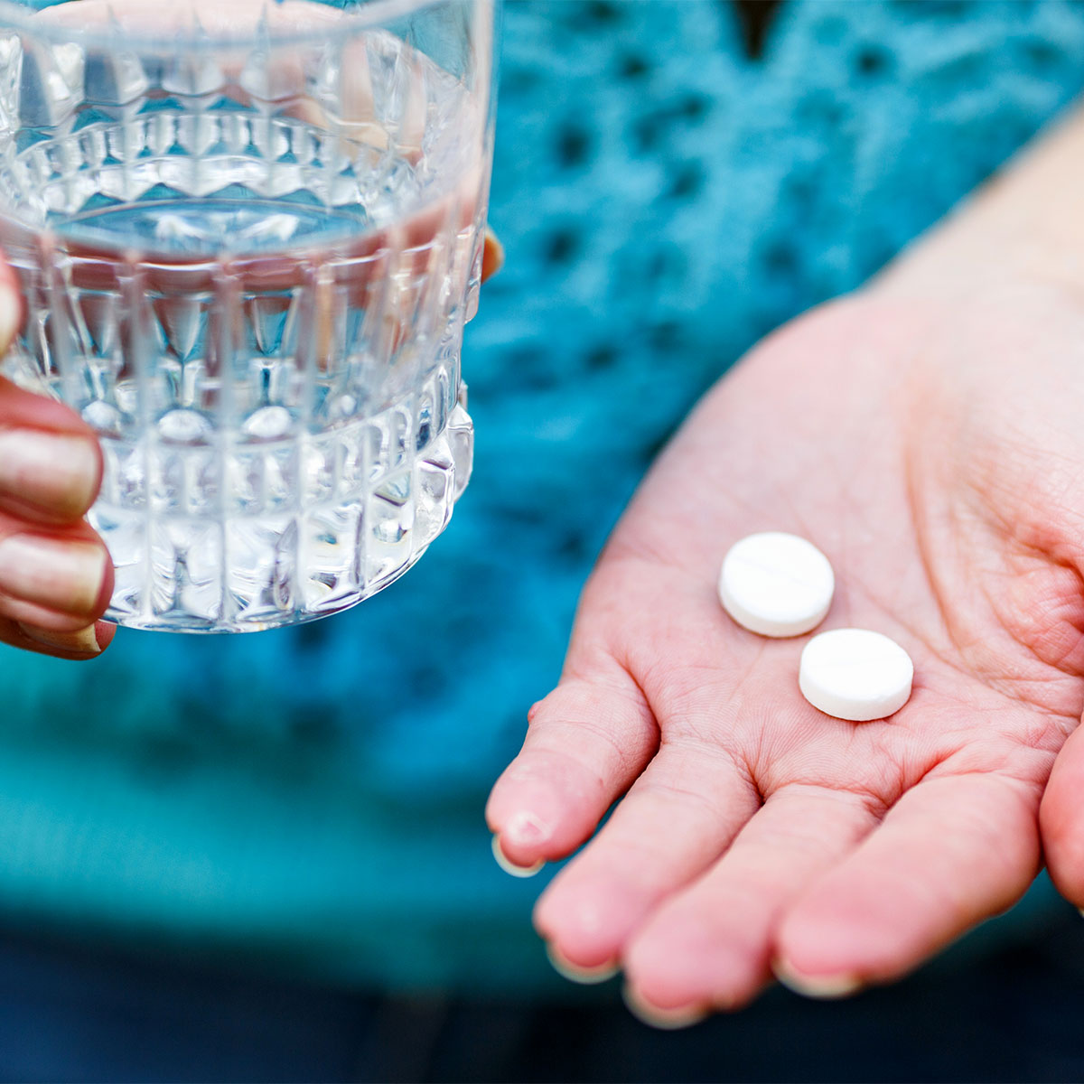 A woman taking vitamins with water